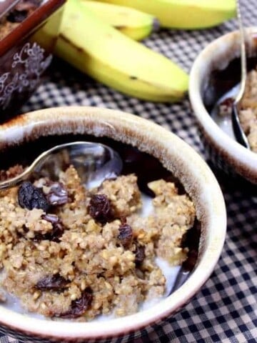 Two bowls of baked steel cut oatmeal on a check tablecloth.