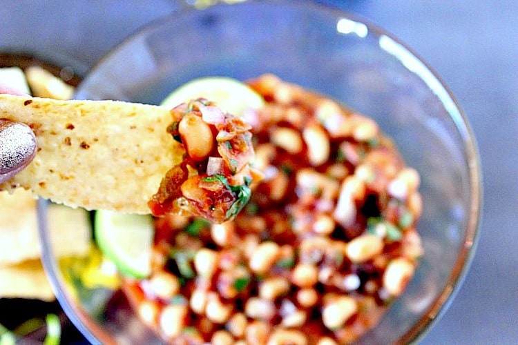 A closeup photo of Black-Eyed Pea Salsa on a tortilla chip