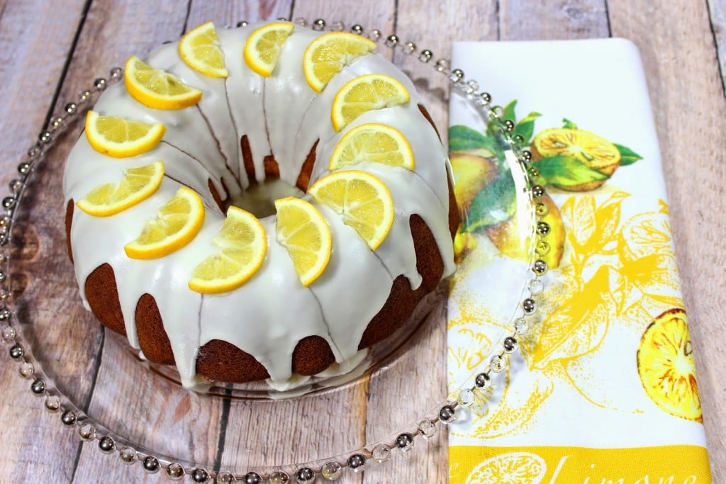 An offset photo of a beautiful Lemon Poundcake with a lemon napkin on the side.