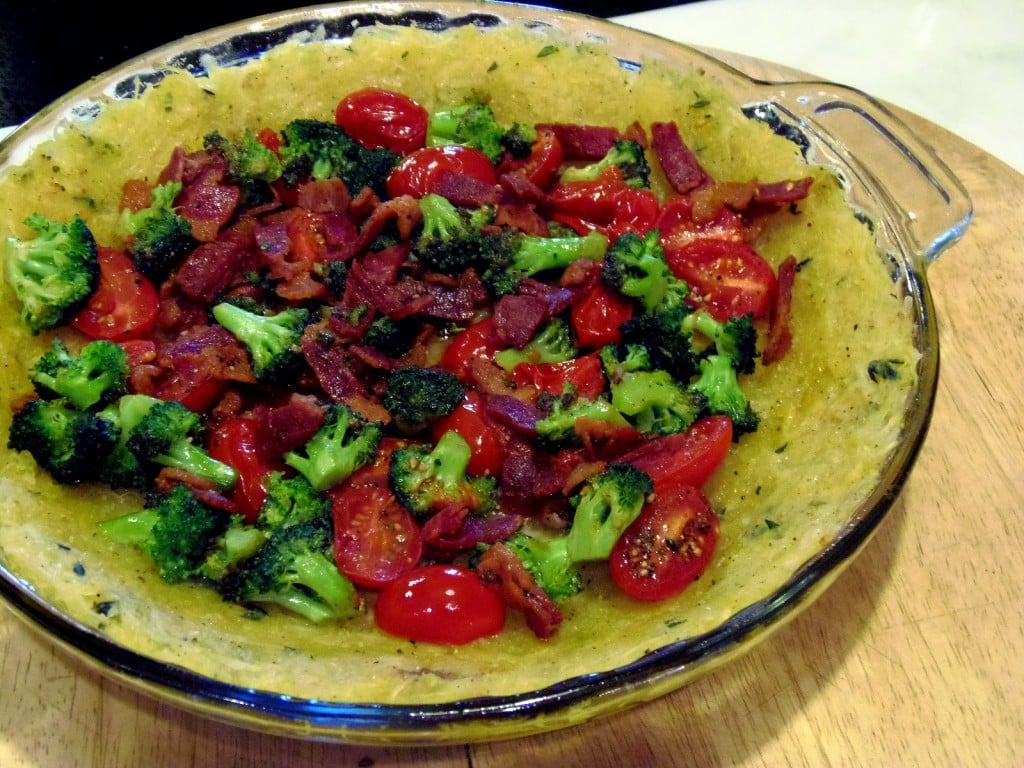 Roasted spaghetti squash is pressed into a pie plate and baked. The "crust" is then filled with veggies, eggs and cheese and baked again. 