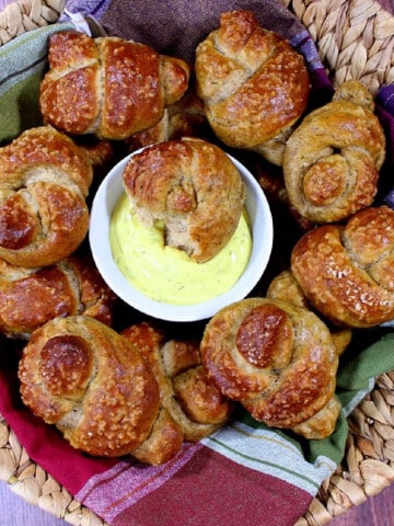 A round basket filled with Whole Wheat Pretzel Knots and a colorful napkin.