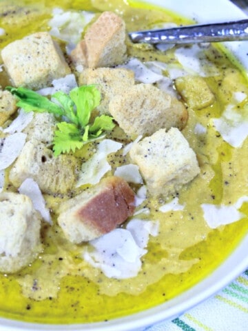 A closeup of a bowl of Roasted Celery Soup with croutons and black pepper.