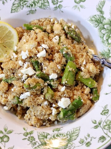A pretty green and white bowl filled with Couscous Salad with Feta and Asparagus.