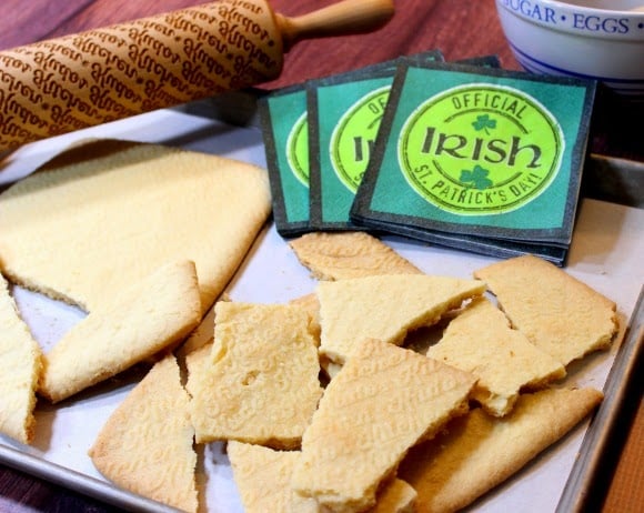 A bunch of broken pieces of Traditional Irish Shortbread along with some Irish napkins in the background.