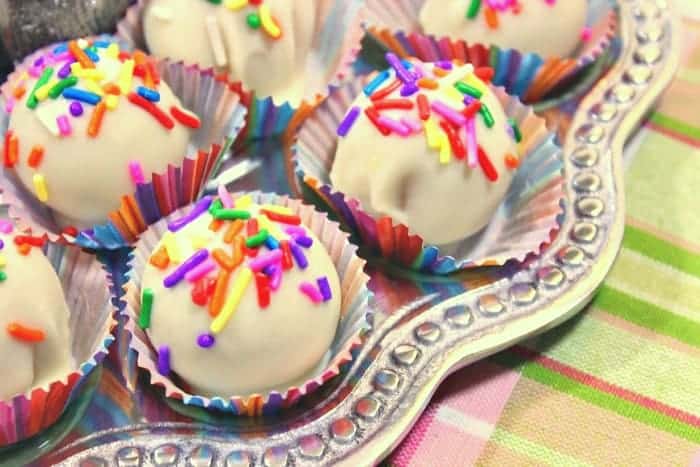 Closeup photo of no-bake shortbread cookie truffles with white chocolate and multi-colored sprinkles