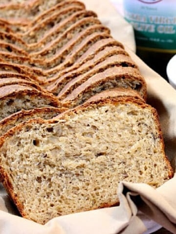 A loaf of sliced Caraway Cheese Batter Bread on a napkin in a bowl.