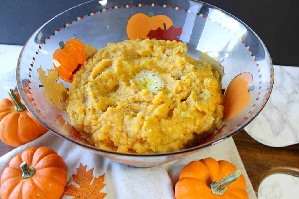 Pumpkin Mashed Potatoes in a hand painted glass bowl with mini pumpkins.