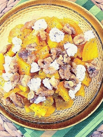 A yellow plate with a Roasted Golden Beet Salad with goat cheese and walnuts.