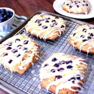 Blueberry Cheese Danish on a rack covered with a vanilla drizzle.
