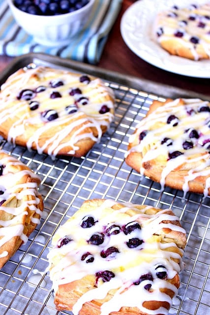 Vertical photo of a baking sheet filled with homemade blueberry cheese Danish.