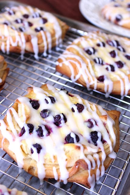 Closeup photo of a cream cheese dansih with blueberries and an icing drizzle