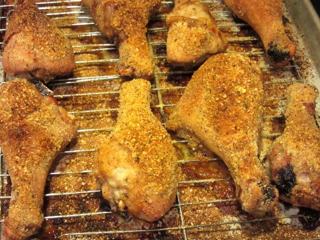 Eight crispy chicken legs on a baking rack.