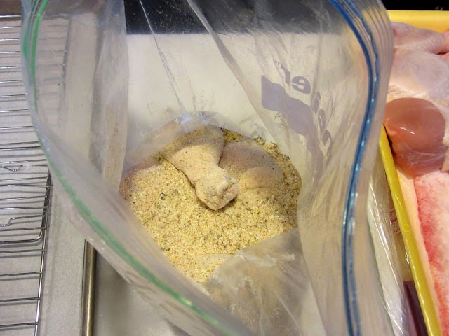 A chicken leg in a plastic bag with breadcrumbs.