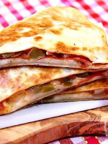 A stack of Pepperoni Pizzadillas with a red and white check napkin in the background.