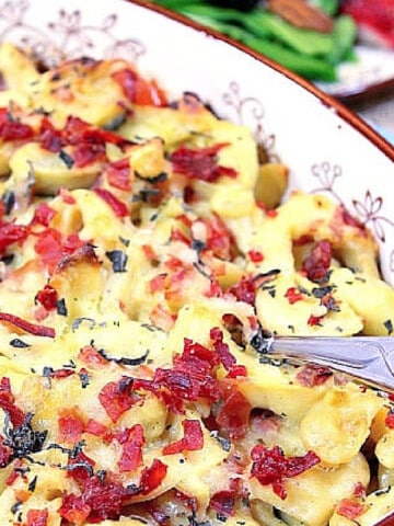 Tortellini Emilia in a casserole dish with a serving spoon.