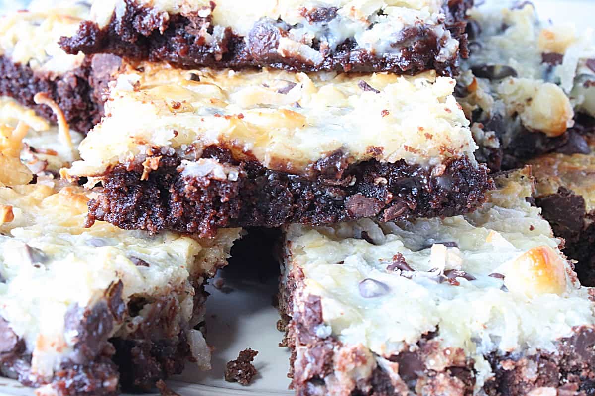 A closeup image of a coconut brownie with macadamia nuts and melted chocolate.