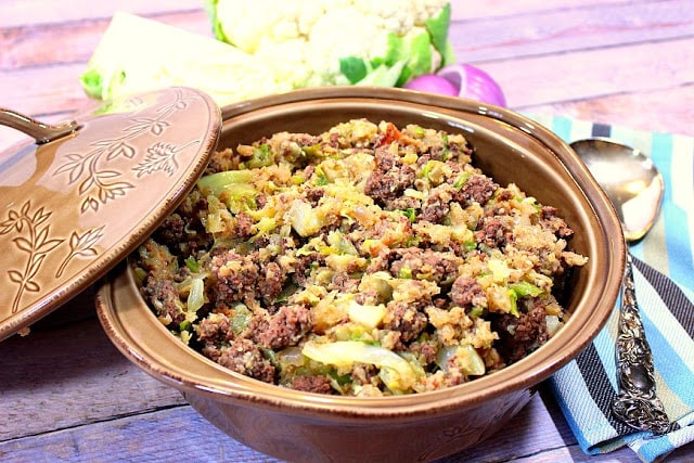 Low carb cauliflower rice in a casserole dish with a lid and a spoon.