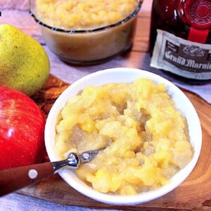 A white bowl filled with Apple Pear Sauce along with a spoon.