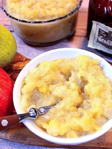 A white bowl filled with Apple Pear Sauce along with a spoon.