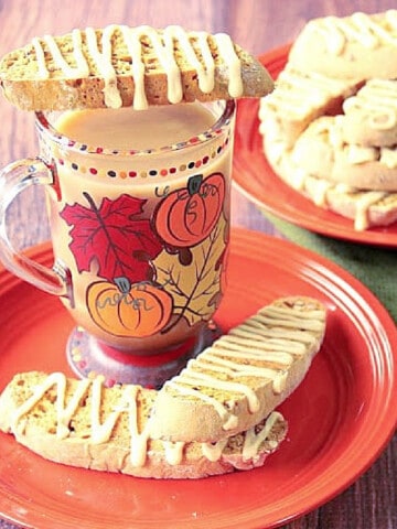 A stack of Pumpkin Banana Biscotti placed on top of a cute autumn coffee mug.