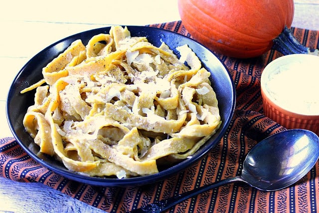 Homemade Pumpkin Pasta with Sage with a pumpkin in the background.