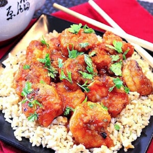 Sweet Chili Shrimp on a bed of rice with cilantro and chopsticks on the side.