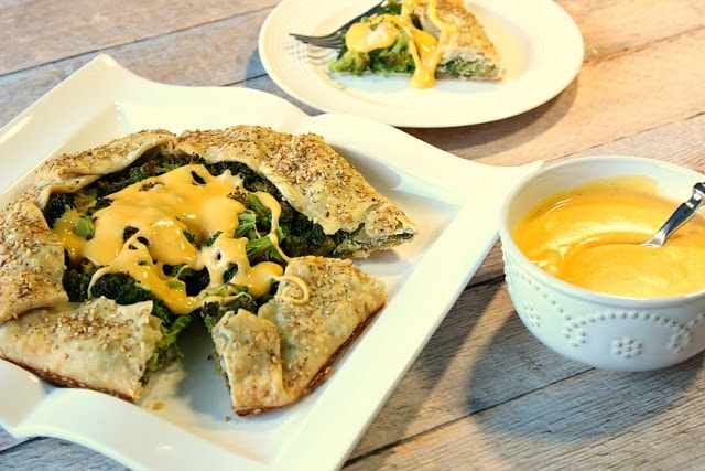 Roasted Broccoli Crostata with Cheese Sauce and a bowl of cheese sauce.