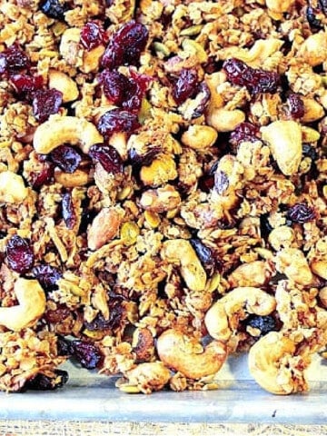 An closeup photo of Coconut Oil Granola with oats, cashews, pistachios and dried cranberries.