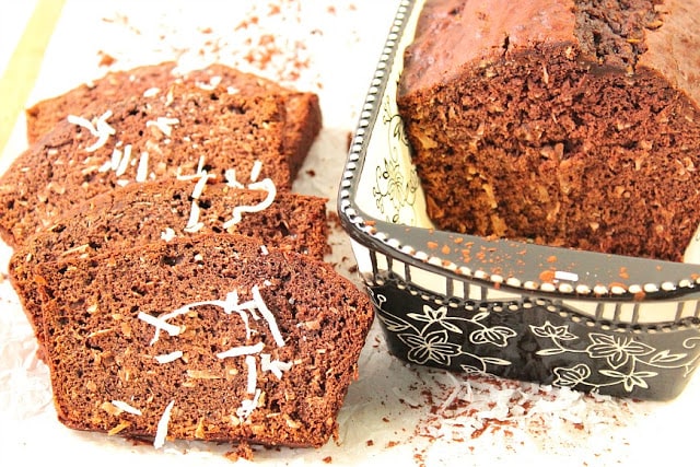 A loaf and a few slices on the side of Chocolate Coconut Banana Bread.