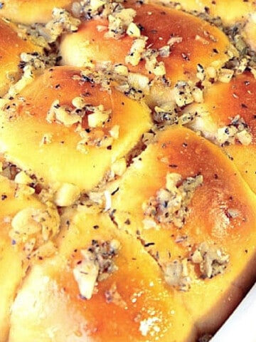A baking dish filled with golden Garlic Yeast Rolls.
