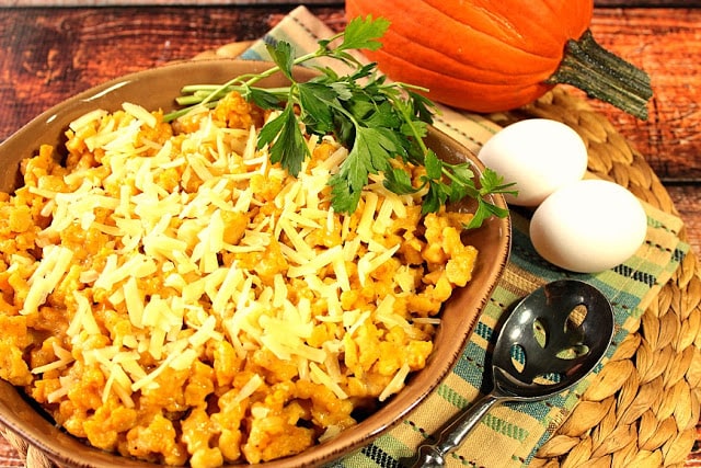 A casserole dish filled with Pumpkin Spaetzle and topped with Gruyere Cheese and parsley.