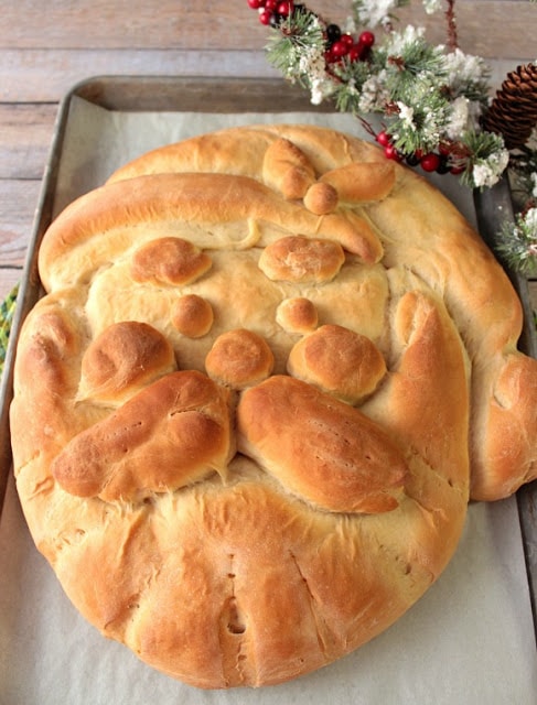 Overhead vertical photo of a buttermilk Santa bread face on a baking sheet. Christmas dinner recipe roundup.