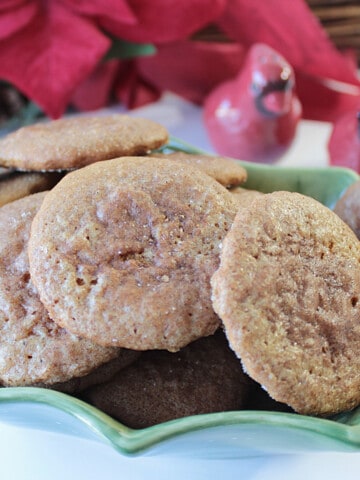 A holly berry serving dish filled with Soft Cinnamon Sugar Gingerbread Cookies.