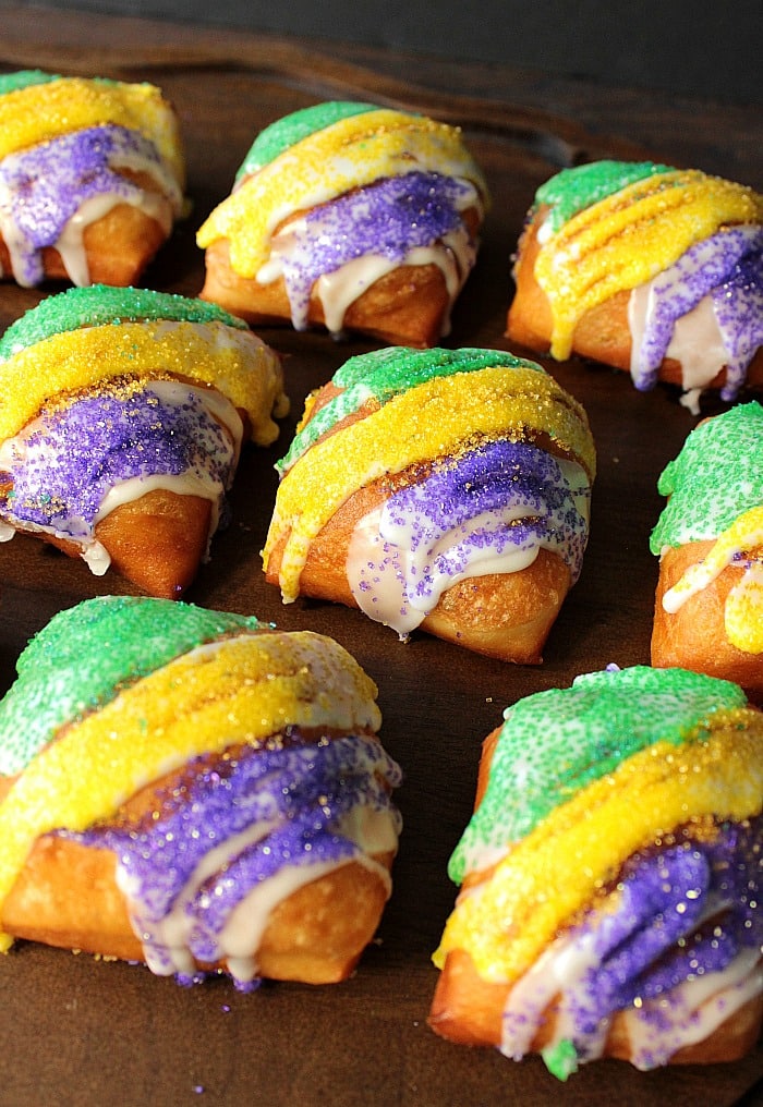 Closeup vertical photo of purple, green, and gold sugared Beignets for Mardi Gras.