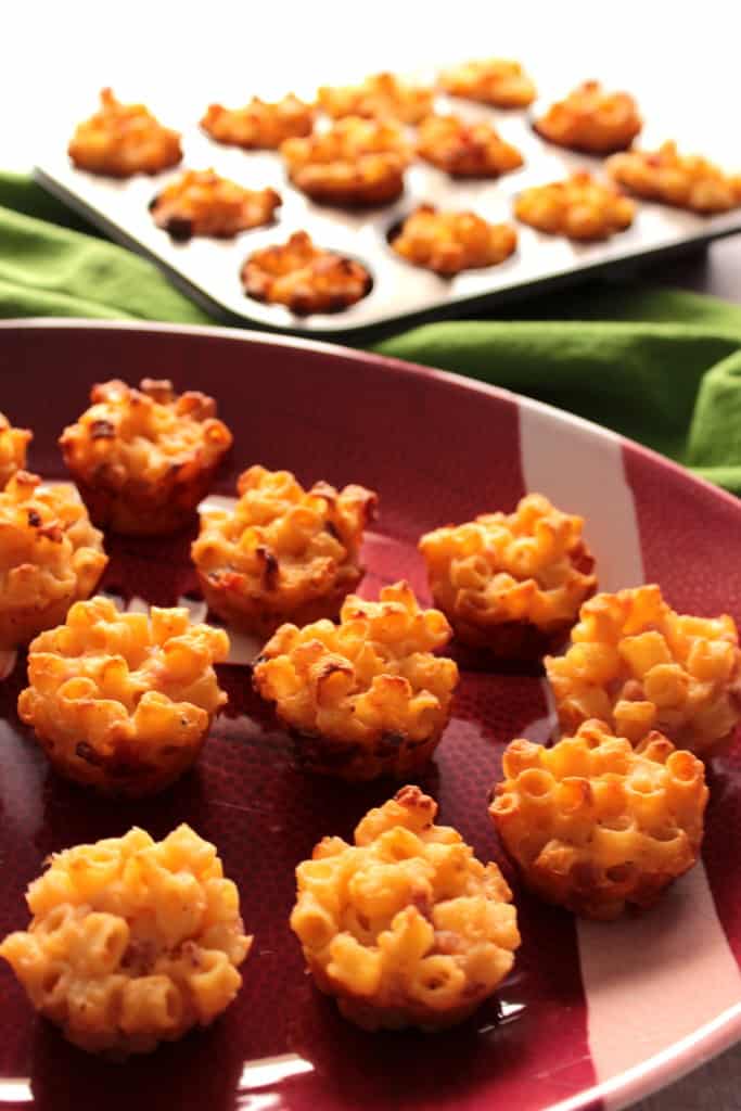 A football platter filled with macaroni and cheese appetizer cups.