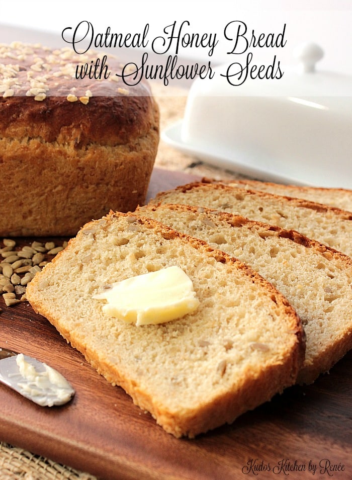 Closeup vertical photo of slices of oatmeal honey bread with a pat of butter.