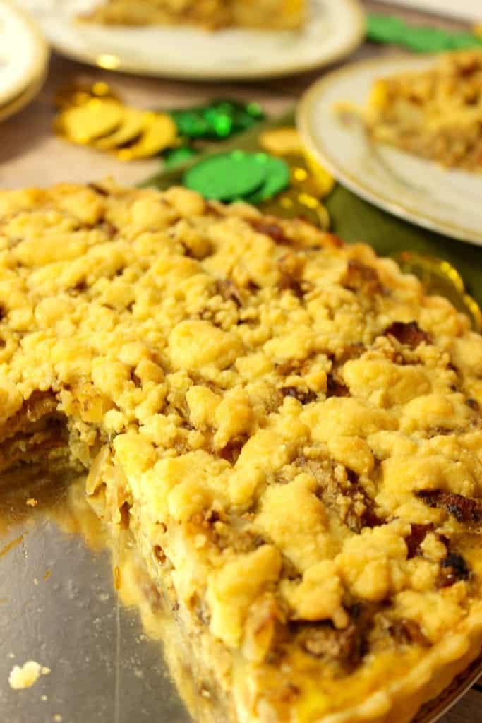 A vertical closeup of an Irish Cheese and Potato Tart with a slice taken out.