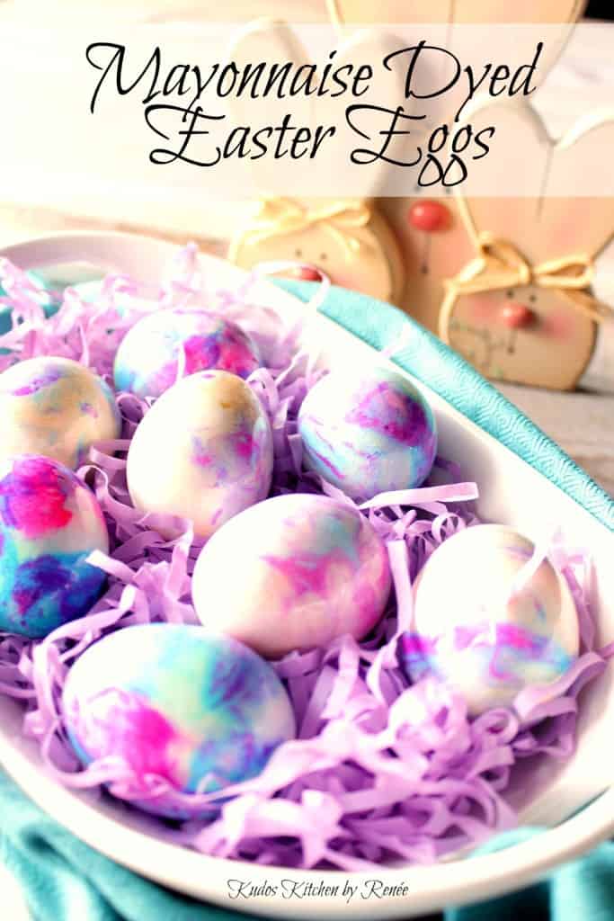 Tie-Dye Easter Eggs in colors of purple, blue, and pink in a white bowl with purple Easter grass.