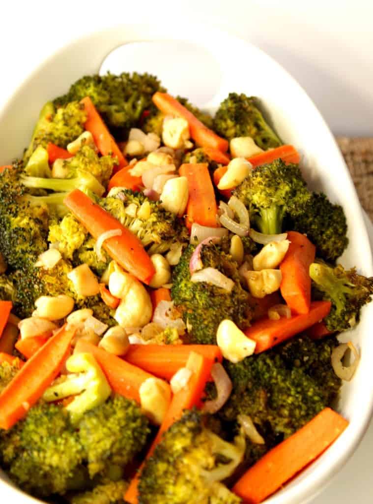 Vertical image of broccoli and carrots in a white bowl.