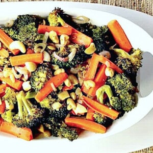 A white bowl filled with Oven Roasted Carrots and Broccoli.