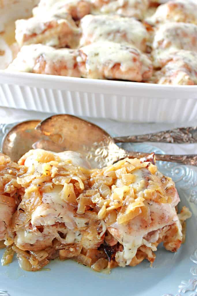 A vertical closeup of French Onion Chicken Thighs on a blue plate and a filled casserole dish in the background.