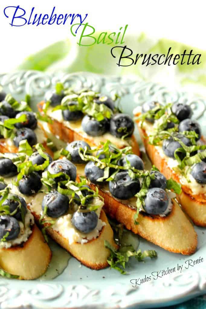 A closeup vertical photo of a bunch of blueberry basil bruschetta appetizers with a title text overlay graphic