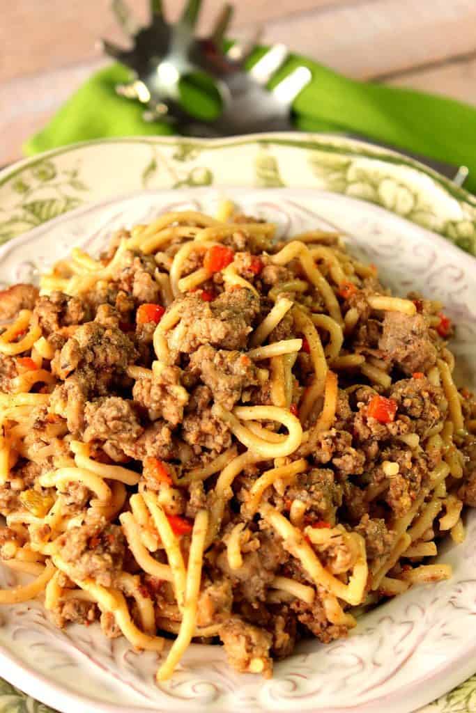 A closeup of Turkey Bolognese Over Spaghetti in a white bowl.