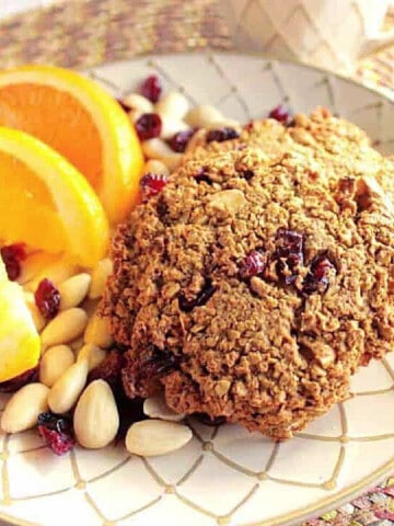 Two Gluten Free Breakfast Cookies on a plate with orange slices.