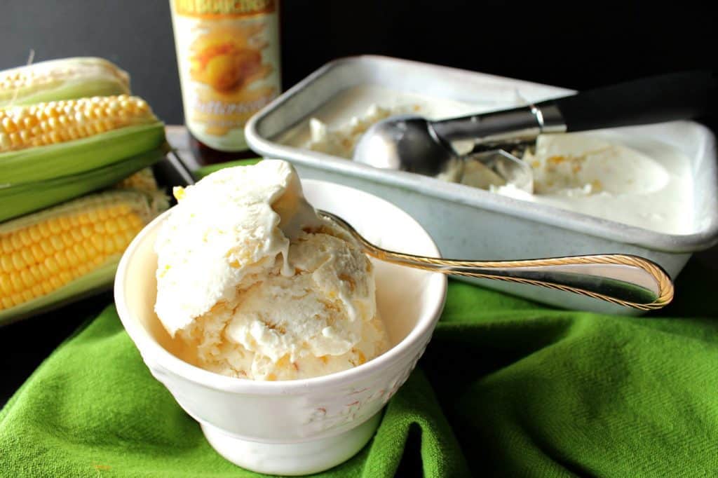 Sweet Corn Butterscotch Ice Cream in a dish with some corn in the background.