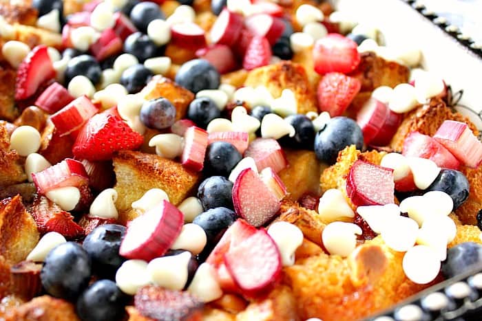 Red White and Blue Bread Pudding - kudoskitchenbyrenee.com Closeup photo of bread pudding with rhubarb, strawberries, blueberries and white chocolate chips.