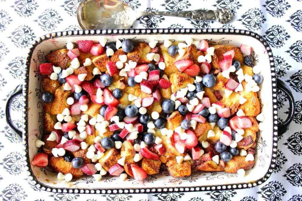 Red White and Blue Bread Pudding - kudoskitchenbyrenee.com Overhead photo of a ceramic dish filled with red white and blue bread pudding with white chocolate.