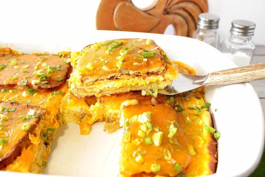 A basic egg sandwich gets an EGG-stra special upgrade when it's turned into this Family Favorite Egg Sandwich Breakfast Casserole. - Kudos Kitchen by Renee A while casserole dish filled with egg sandwich breakfast casserole.