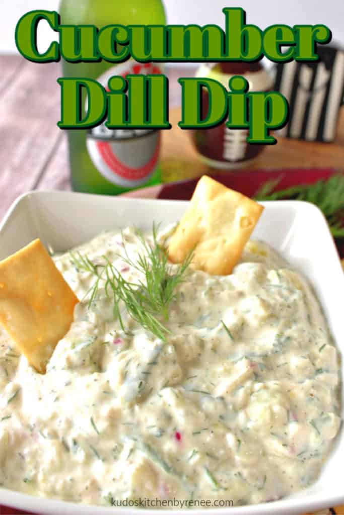 Closeup photo of cucumber dill dip in a bowl with two crackers and title text graphic overlay