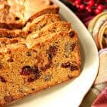 Quick Bread with Cranberries, Chocolate and Pecans on a serving plate.